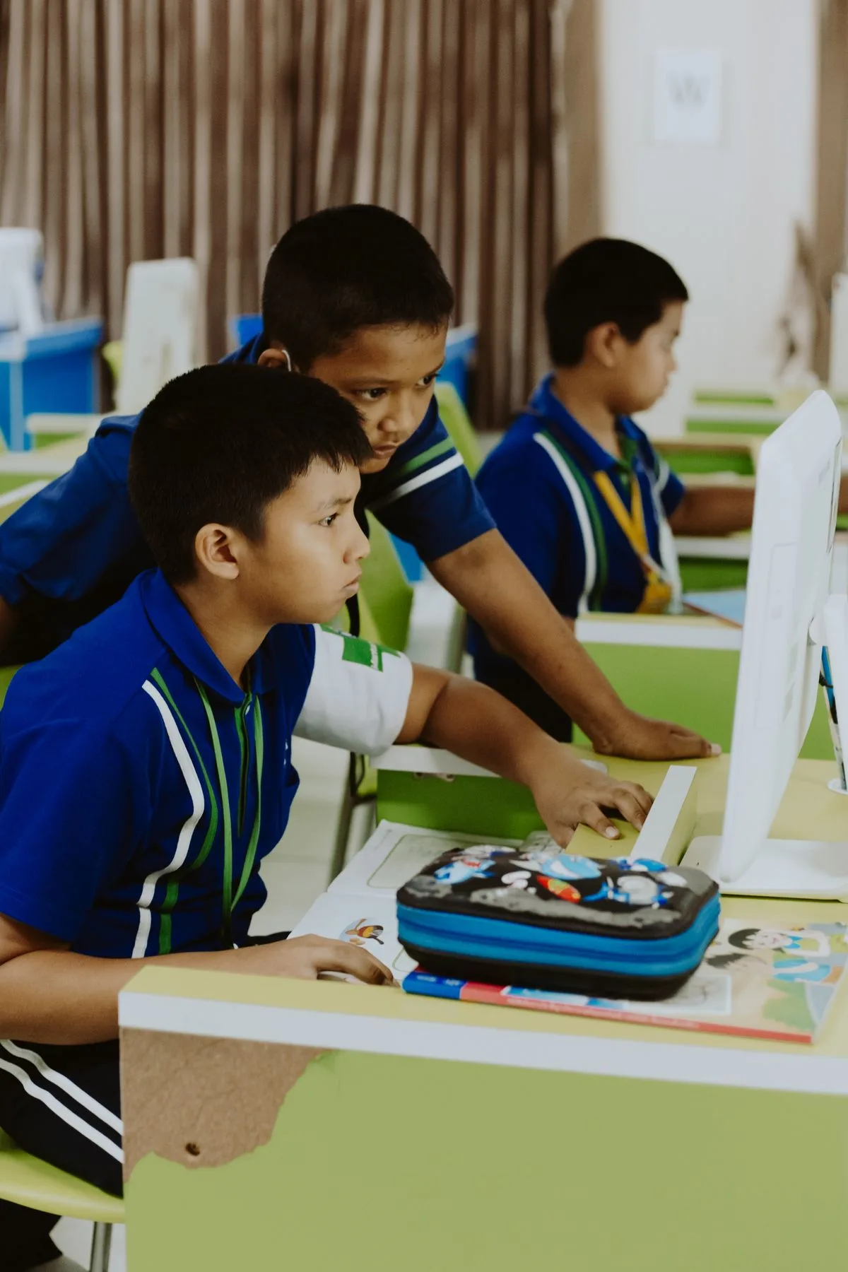 Indian schoolboys working on a desktop computer