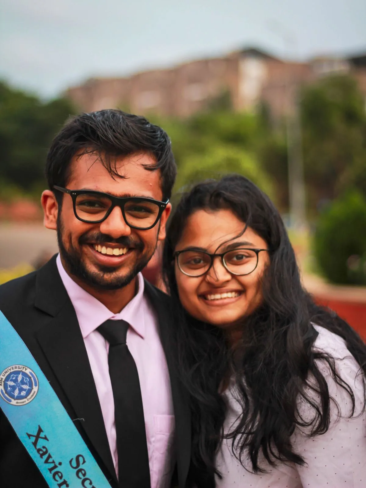 Two smiling Indian graduates in convocation gowns