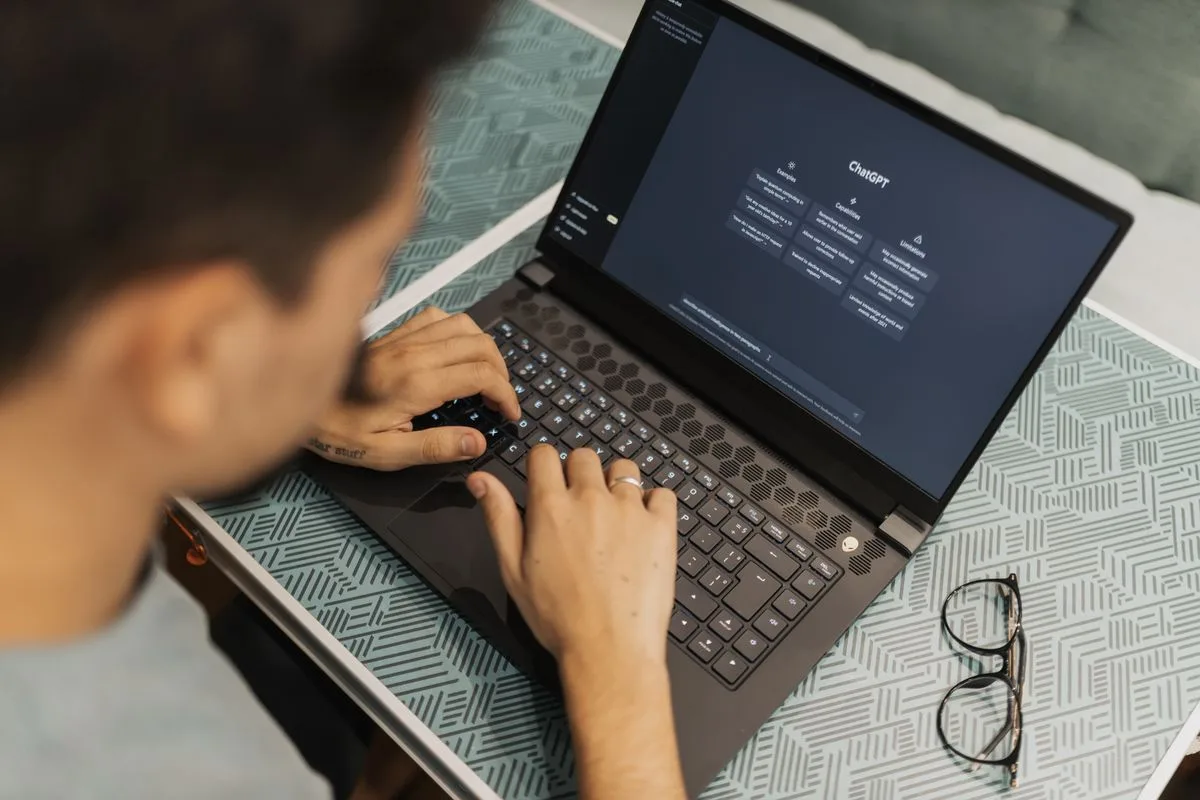 Person writing an AI prompt on a laptop