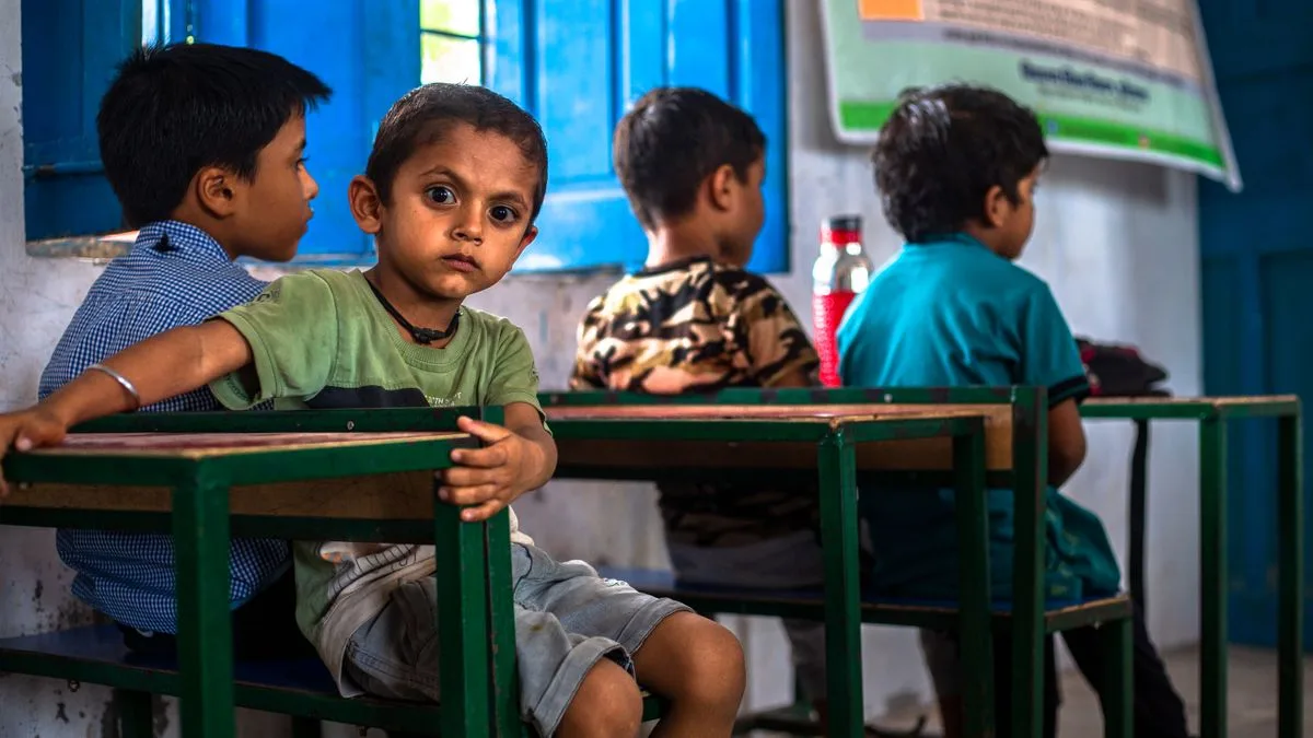 Indian schoolboy sitting at his desk in a classroom
