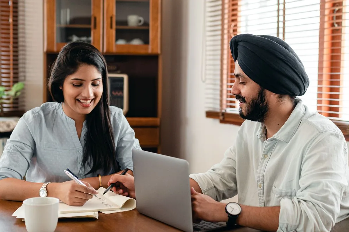 Indian students using a laptop together at home