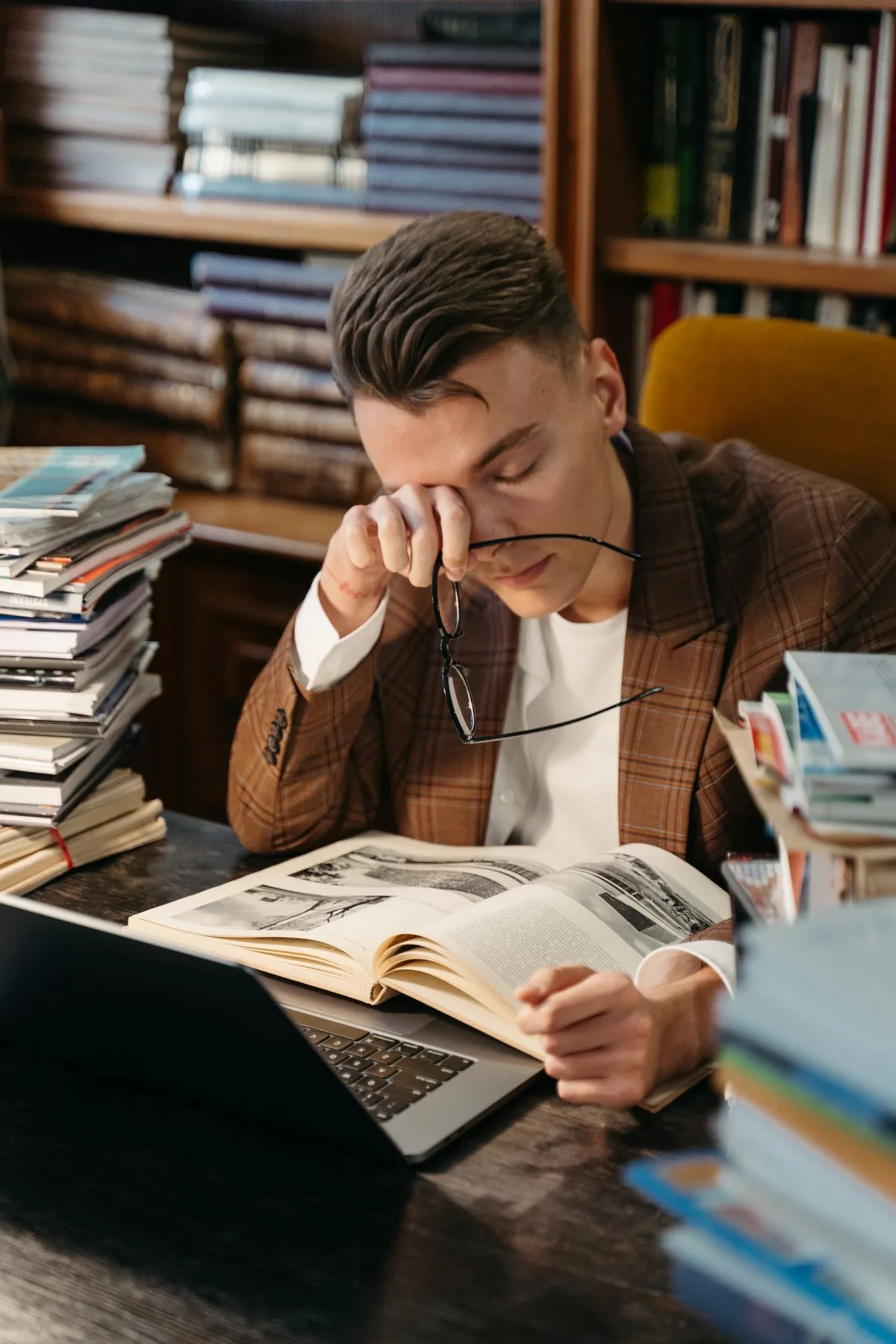 Tired student rubbing his eyes in front of a laptop